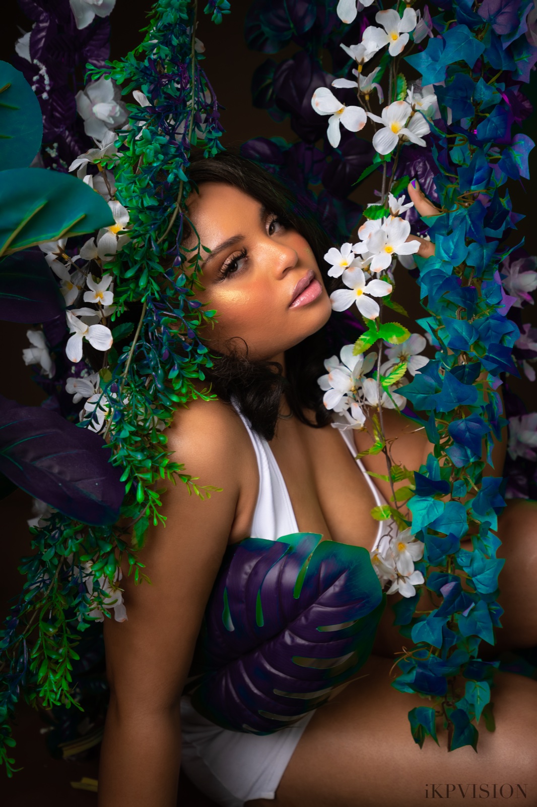 Portrait framed by white flowers and colorful foliage.